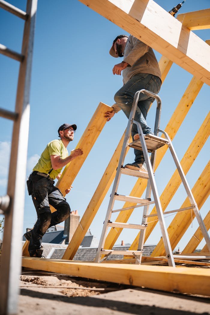 The Art of Drawing Readers In: Your attractive post title goes here Two construction workers building a wooden roof structure on a sunny day.